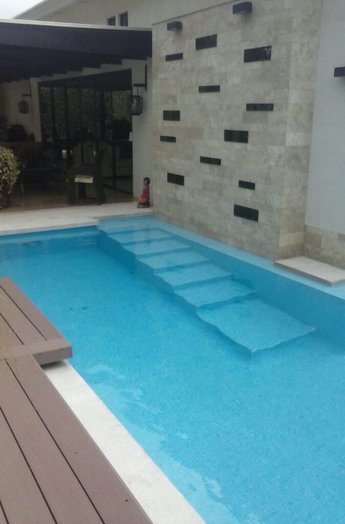 blue tiling pool, pool builder, with coraline stone walls